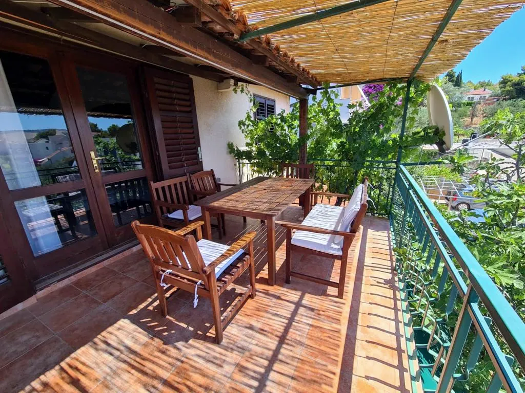 The terrace along the house, the table under the reeds